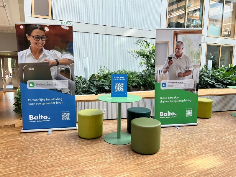 Twee Balto-banners en een tafel met QR-code in een hal